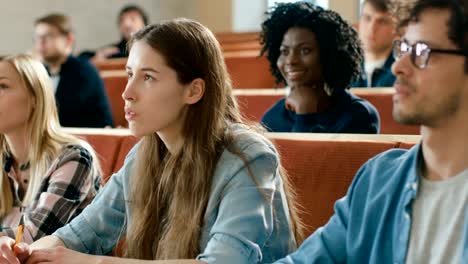 En-el-aula-Multi-étnica-estudiantes-escuchando-a-un-profesor-y-escribir-en-los-cuadernos.-Inteligente-estudio-en-la-Universidad-de-los-jóvenes.