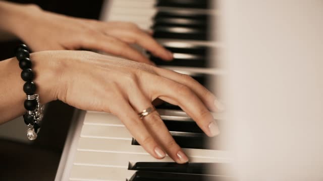 Weibliche-Hände-spielen-Klavier.-Frau-berührt-Finger-auf-Tasten.-Nahaufnahme