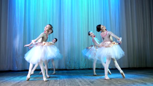ballet-rehearsal,-on-the-stage-of-the-old-theater-hall.-Young-ballerinas-in-elegant-dresses-and-pointe-shoes,-dance-elegantly-certain-ballet-motions,-pass,-arabesque,-tempiplie
