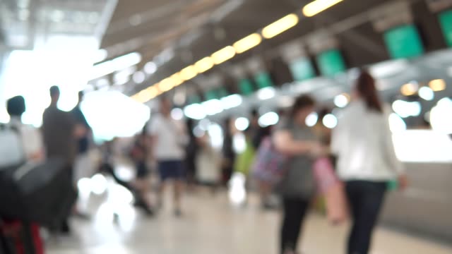 Blurred-footage-of-passengers-walking-to-check-in-counter-at-International-airport-terminal.-4K-video-with-defocused-effect.