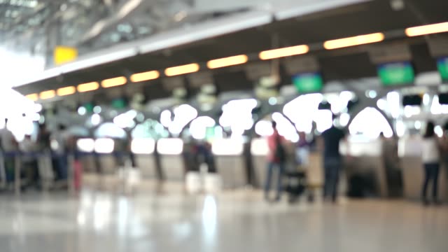Unscharfe-Aufnahmen-der-Passagiere-zu-Fuß-zum-Check-in-Schalter-am-Flughafen-terminal.-4K-Video-mit-defokussierten-Wirkung.