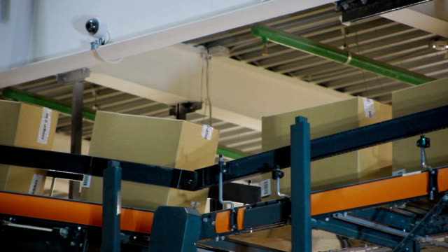 Cardboard-boxes-on-conveyor-belt-inside-warehouse