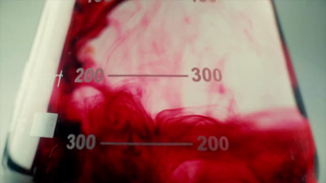 Farbige-wunderschöne-chemische-Reaktion-In-Kolben.-Rote-Flüssigkeit-auflöst-In-Flasche