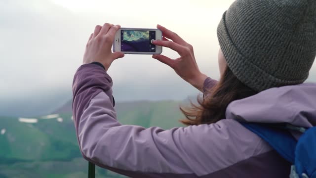 Woman-taking-photograph-smartphone-sharing-photo-of-landscape-nature-background-enjoying-vacation-holiday-travel-adventure