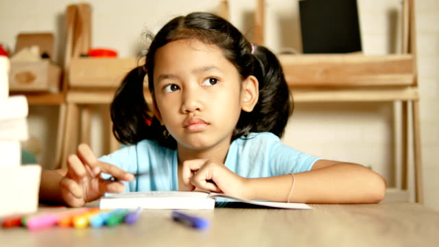 Das-kleine-Mädchen-Hausaufgaben-machen-und-denke-etwas