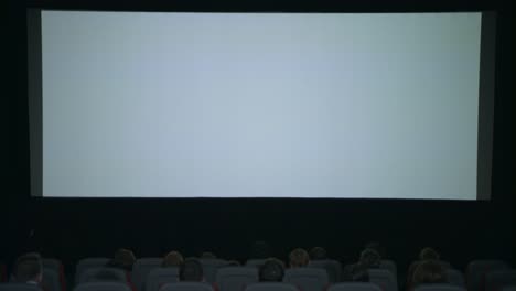 Large-white-screen-in-cinema.-Beginning-film-in-cinema.-Cinema-screen-people