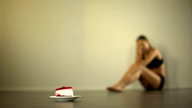 Skinny-model-feels-nausea-when-looking-at-cake,-anorexia,-eating-disorder