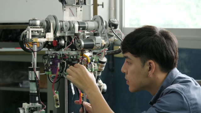 Asiatische-junge-Elektronik-Ingenieur-Bau-&-Befestigung-Robotik-im-Labor.-Menschen-mit-Technologie-oder-Innovation-Konzept.
