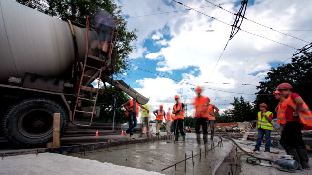 Concrete-works-for-road-maintenance-construction-with-many-workers-and-mixer-timelapse-hyperlapse