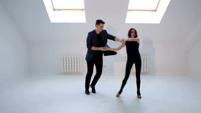 Flexible-Tänzer-tanzen-Gesellschaftstänze-in-einem-hellen-Raum-mit-kleinen-Fenstern.