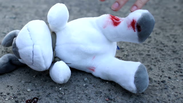 Shocked-mother-taking-bloody-toy-in-hands,-death-of-child-in-road-accident