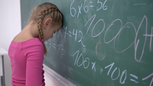 Schulbildung,-weibliche-Schüler-müde-Studien-stehen-in-der-Nähe-von-Blackboard-mit-Mathematik-Beispiele