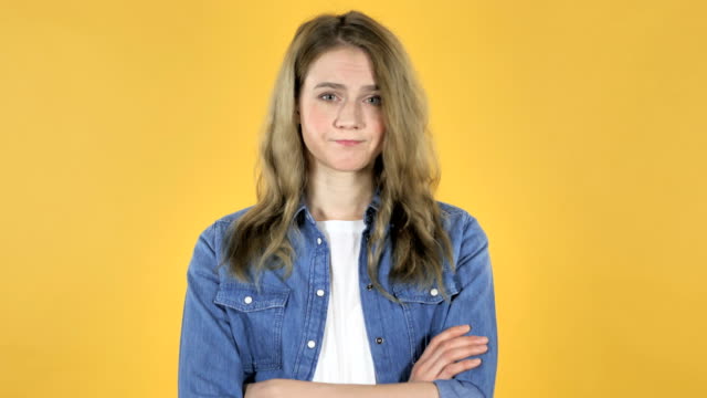 Young-Pretty-Girl-Shaking-Head-to-Reject-on-Yellow-Background