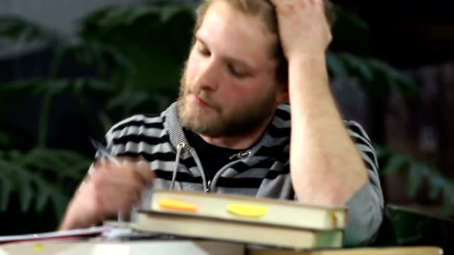 Ein-College-Student-sitzt-an-seinem-Schreibtisch-mit-Büchern-vor-ihm
