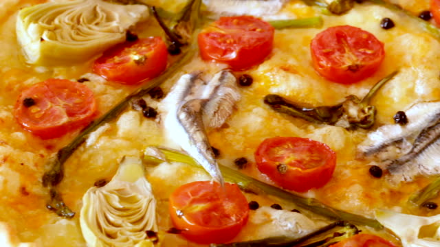 Pizza-with-anchovies,-artichokes,-cheese-and-sun-dried-tomatoes