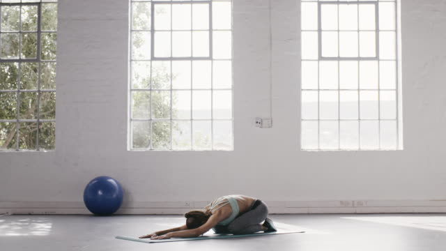 Woman-doing-child-pose-in-yoga-studio