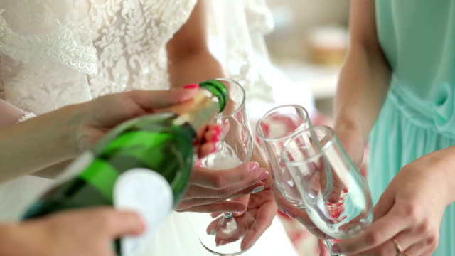 Close-up-of-the-girl-poured-champagne-into-glasses-at-a-bachelorette-party.