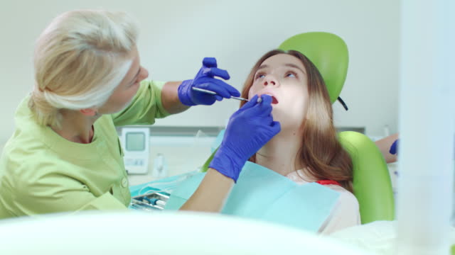 Stomatologie-Spezialisten-arbeiten-mit-Patienten-in-Zahnklinik.-Zahnärztin