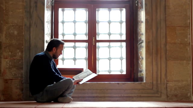 Young-muslim-reading-holy-book-(qoran)-in-mosque