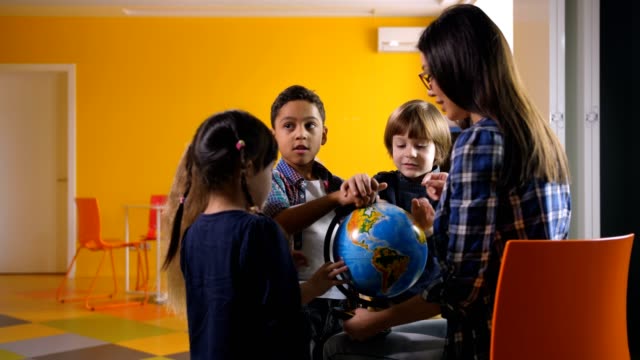 Diverse-Kinder-und-Lehrer-mit-Globus-im-kindergarten
