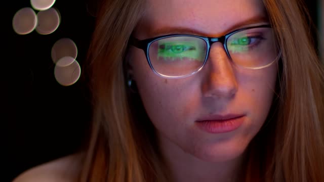Nahaufnahme-von-Brille-caukasian-blonde-Frau,-mit-Blick-auf-Computerbildschirm-und-es-ist-in-ihrer-Brille,-dunklen-Hintergrund,-fokussierte-Person,-Smart-Vibes-reflektiert
