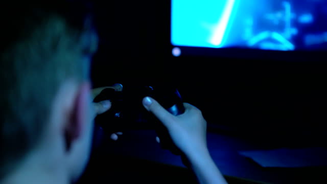 4K-Boy-spielen-Videospiele-sitzen-in-der-Dunkelheit