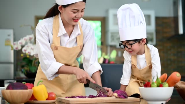Beautiful-Asian-woman-and-cute-little-boy-with-eyeglasses-prepare-to-cooking-in-kitchen-at-home-together.-Lifestyles-and-Family.-Homemade-food-and-ingredients.-Two-people-making-Ketogenic-diet-salad