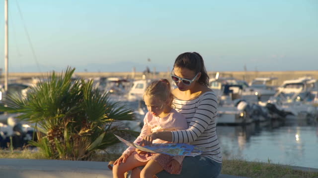Woman-with-Daughter-Reading-Map-near-Marina