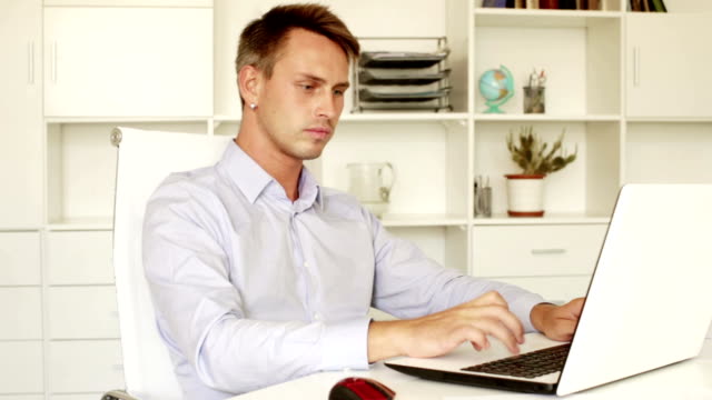 hombre-joven-en-ropa-de-etiqueta-trabajando-con-ordenador-portátil