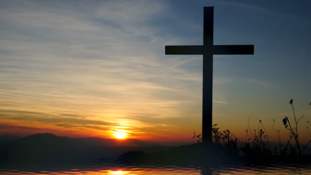 Kreuz-des-Jesus-Christus-in-der-Nähe-von-Wasser-mit-Sonnenuntergang-und-friedliche-Stimmung.