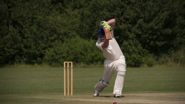 Un-jugador-de-críquet-de-bateo-conduce-la-bola-en-cámara-lenta.