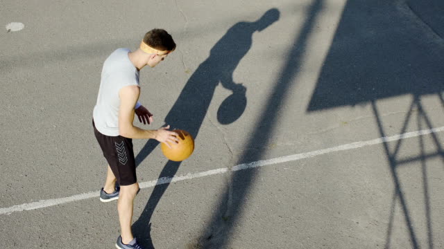 Young-Caucasian-basketball-player-dribbling-a-ball-at-stadium,-sport-and-hobby