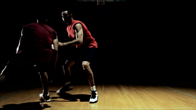 A-basketball-player-goes-against-a-defender-and-spins-around-him.