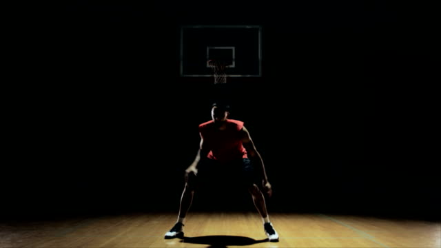Un-jugador-de-baloncesto-botando-y-practicar-en-la-cancha.