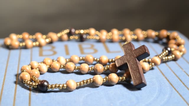 Rotation-of-wooden-rosary-on-the-bible