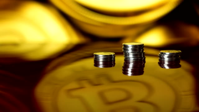 Time-lapse-growing-rising-columns-stack-pile-of-bitcoin-cryptocurency-mining-business-cash-exchange-success-on-reflecting-table-with-blurred-bokeh-background-crypto-currency