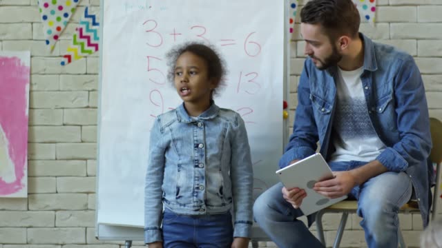 Kleines-Mädchen-im-Gespräch-mit-Klassenkameraden-im-Kindergarten-Lektion