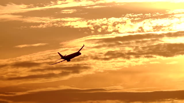 Flugzeug-auf-Sonnenuntergang-Hintergrund.-Slow-Motion