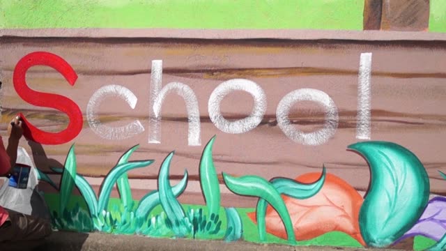 Mural-painter-draws-a-word-School-on-school-wall.-time-lapse