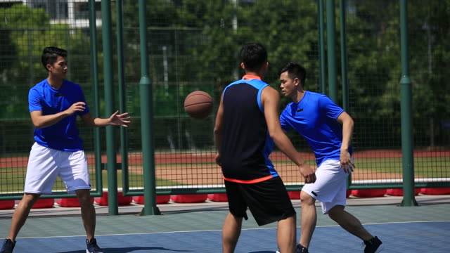 Junge-asiatische-Erwachsene-spielen-Basketball-im-freien
