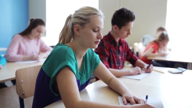 Gruppe-von-Studenten-mit-Notebooks-Test-in-der-Schule-schreiben