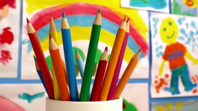 Color-Pencils-In-Classroom-With-Paintings-On-Wall