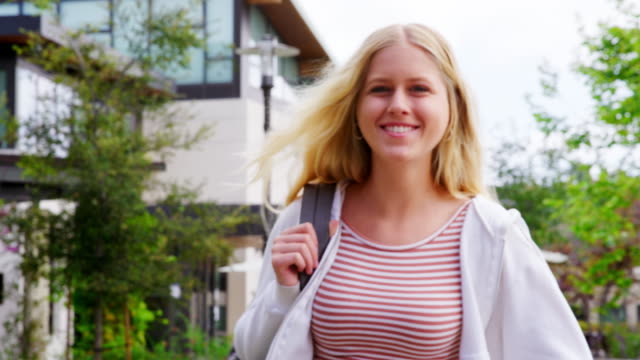 Portrait-Of-Female-High-School-Student-Outside-College-Buildings-Shot-In-Slow-Motion