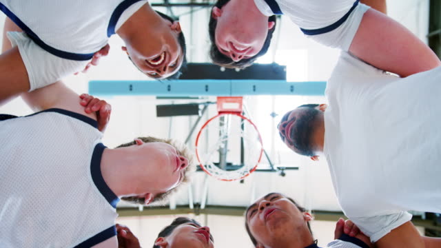 Niedrigen-Winkel-Ansicht-der-männlichen-High-School-Basketball-Spieler-mit-Teamsitzung-mit-Trainer