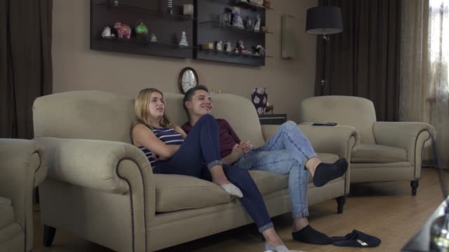 Schönes-Paar-in-Liebe-zu-Hause-auf-der-Couch-vor-dem-Fernseher