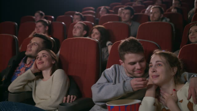 Amor-parejas-viendo-la-película-en-el-cine.-Jóvenes-comiendo-palomitas-de-maíz