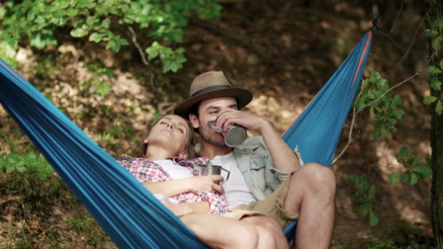 Couple-in-love-relaxing-on-hammock-in-forest