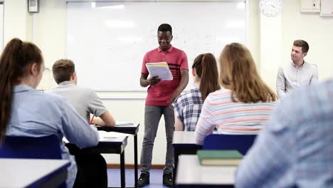 Male-Student-Giving-Presentation-To-High-School-Class-In-Science-Lesson