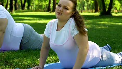 Clases-de-yoga-para-personas-obesas,-gorda-chica-haciendo-asanas,-esperando-a-final-de-ejercicio