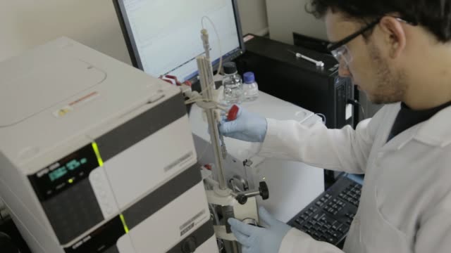 Ein-handheld-Schuss-eines-Forschers-Überprüfung-einer-HPLC-in-einem-genetischen-Labor-an-der-Universität